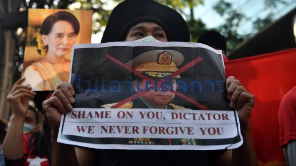 A Myanmar migrant holds up a poster with the image of Myanmar's Chief Senior General Min Aung Hlaing, commander-in-chief of the Myanmar armed forces, as they take part in a demonstration outside the Myanmar embassy in Bangkok on February 1, 2021, after Myanmar's military detained the country's de facto leader Aung San Suu Kyi and the country's president in a coup. Lillian SUWANRUMPHA / AFP