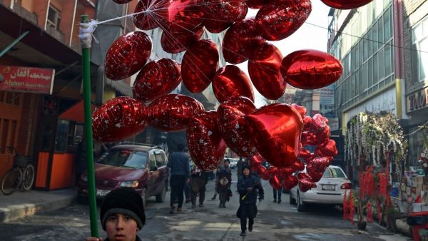 A child carries balloons to sell on Valentine's Day in Kabul on February 14, 2021. WAKIL KOHSAR / AFP