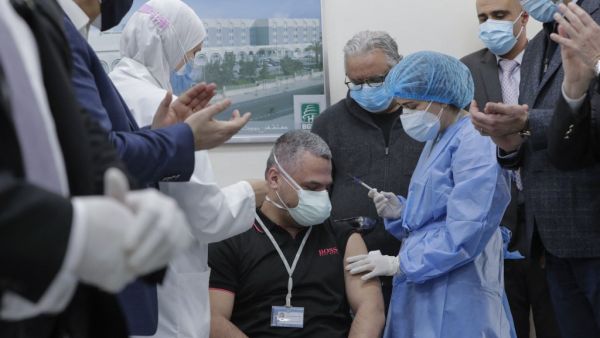 Head of the intensive care unit at Lebanon's Rafik Hariri Hospital battling the coronavirus, Mahmoud Hassoun, receives the first jab of the COVID-19 Pfizer/BioNTech vaccine at the hospital premises as the country kickstarts its inoculation campaign, in the capital Beirut, on February 14, 2021. Lebanon gave its first COVID-19 vaccine dose to a doctor, as it started inoculation it hopes will keep the pandemic in check amid a deepening economic crisis. ANWAR AMRO / AFP