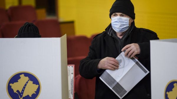 A Kosovo Albanian man prepares to cast his vote during Parliamentary elections at a polling station in Pristina on February 14, 2021. Kosovo heads to the polls in a vote pitting a left-wing reformist party against traditional elites who have run the former Serbian province for the past decade. Armend NIMANI / AFP
