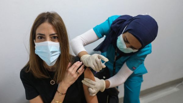 A medic administers a dose of the COVID-19 Pfizer/BioNTech vaccine at Lebanon's American University Medical Center in the capital Beirut, on February 14, 2021, as the country kickstarts its inoculation campaign. Lebanon gave its first COVID-19 vaccine dose to a doctor, as it started inoculation it hopes will keep the pandemic in check amid a deepening economic crisis. ANWAR AMRO / AFP