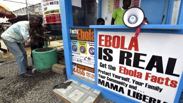 In this file photograph taken on September 30, 2014, Liberians wash their hands next to an Ebola information and sanitation station, raising awareness about the virus in Monrovia. Pascal GUYOT / AFP