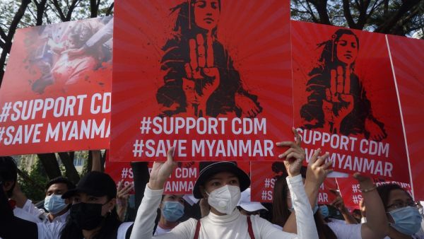 Protesters hold up signs supporting the Civil Disobedience Movement (CDM) during a demonstration against the military coup in Yangon on February 15, 2021. Sai Aung Main / AFP