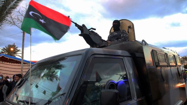 Members of Libyan security forces take part in a military parade on the eve of celebrations marking the 10th anniversary of the revolution in the port city of Tajoura, on February 16, 2021. Libyans mark on February 17 the tenth anniversary of the start of a revolution that toppled dictator Moamer Kadhafi, a pyrrhic occasion for many, in a country still engulfed in chaos. Mahmud TURKIA / AFP