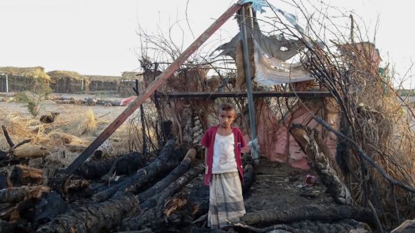 A displaced Yemeni youth stands in the midst of calcined wooden poles after a fire broke out in a shelter in the war-ravaged western Hodeida province, on February 16, 2021. Khaled Ziad / AFP