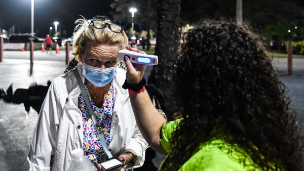 Attendees get their temperature checked as they arrive for the performance of "La Bohème" on stage for the first mainstream opera performance in the US since the beginning of the Covid-19 pandemic, organized by the Palm Beach Opera's outdoor festival at the iTHINK Financial Amphitheater in West Palm Beach, on February 19, 2021.  AFP