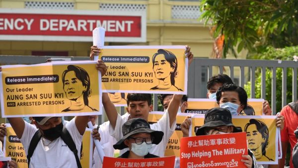 Protesters hold placards and display images of ousted civilian leader Aung San Suu Kyi as they take part in a demonstration against the military coup, in front of the Chinese embassy in Yangon on February 21, 2021. Sai Aung Main / AFP