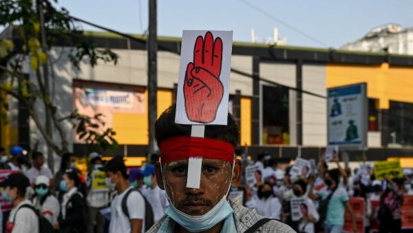 A protesters wears a sign with the three finger salute during a demonstration against the military coup in Yangon on February 22, 2021. Ye Aung THU / AFP