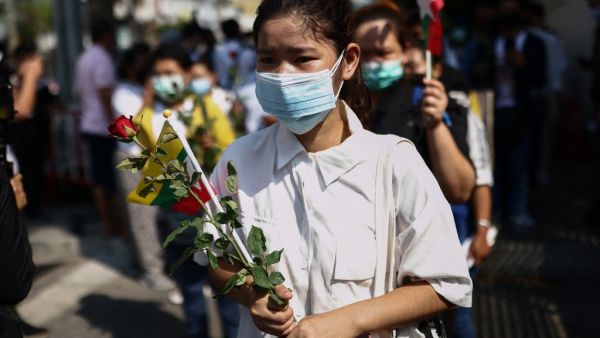 A protester places flowers as Myanmar migrants living in Thailand hold a demonstration remembering protesters killed while rallying against the military coup in their home country, and calling for the results of the 2020 Myanmar election to be upheld, outside the Indonesian ambassy in Bangkok on February 23, 2021. Jack TAYLOR / AFP
