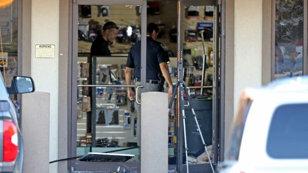 A body lies just inside the shattered front door at the Jefferson Gun Outlet as investigators work the scene on February 20, 2021 in Metairie, Louisiana. According to reports, three people were killed and two injured after an altercation lead to gunfire at an indoor shooting range. Michael DeMocker/Getty Images/AFP