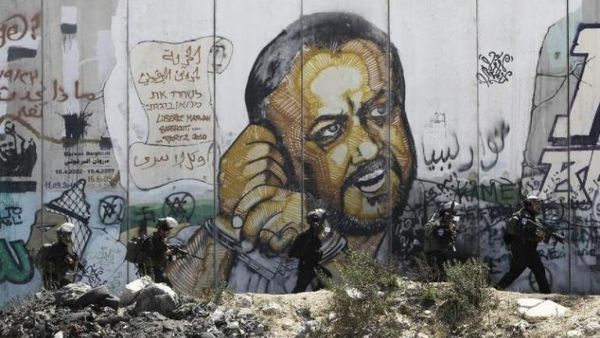 A mural depicts Marwan Barghouti at the Israeli Qalandiya checkpoint between Jerusalem and Ramallah in the occupied West Bank (AFP)