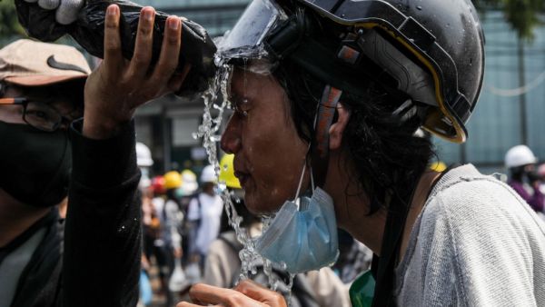 A protester seeks to keep the tear gas away