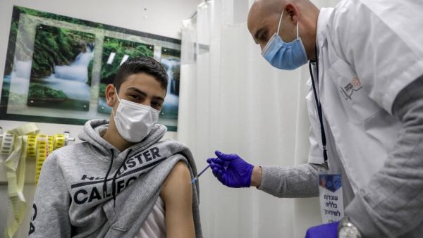 A health worker administers a dose of the Pfizer-BioNtech COVID-19 vaccine on a man 