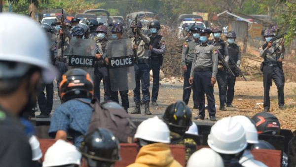 Riot police hold their firearms as they face off with protesters 