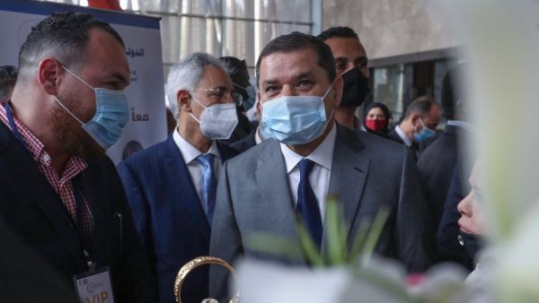 Libya's  interim PM Abdul Hamid Dbeibah (C) arrives to deliver a speech at a conference on COVID-19 in Tripoli