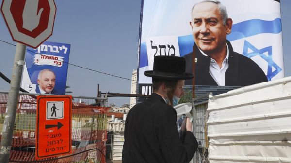 An Ultra-Orthodox Jew walks past roadworks as above hang election campaign posters of Israel's Yisrael Beiteinu party bearing a portrait of its leader Avigdor Liberman (L) and the Likud party showing its leader and incumbent Prime Minister Benjamin Netanyahu (R) on a construction site in the Israeli central city of Bnei Brak, on March 14, 2021. On March 23, the Netanyahu faces his fourth re-election contest in less than two years, after repeatedly failing to unite a coalition behind him, despite his devoted right-wing base. JACK GUEZ / AFP Netanyahu in a fighting mood!