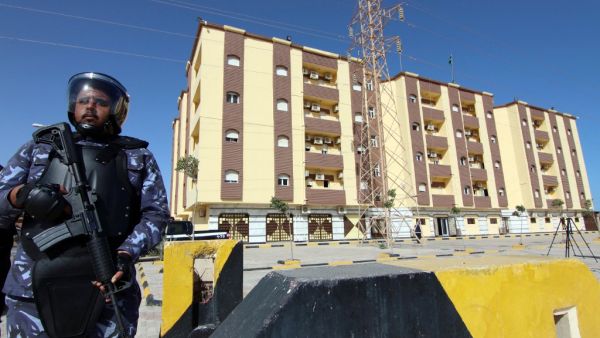Libyan security forces stand guard outside the entrance to the conference center 