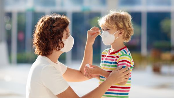 Family with kids in face mask in shopping mall 