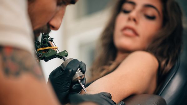 What is the Tattoo artist doing?