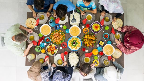 Family and friends gather at home to eat dinner