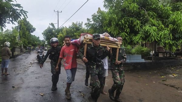 Villagers carry the body of a victim after flash floods in Lembata, East Flores, on April 5, 2021, as torrential rains triggered floods and landslides that have killed at least 91 people and left dozens missing in Indonesia and neighbouring East Timor. HANDRIANUS EMANUEL / AFP Flash floods leave thousands missing in Indonesia
