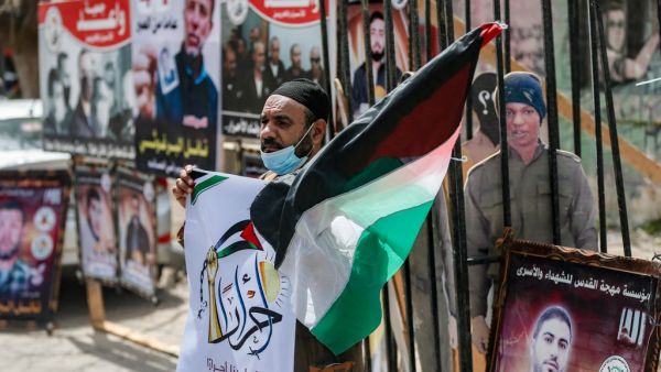A Palestinian carries a national flag in a rally in support of prisoners held in Israeli jails, in Gaza City