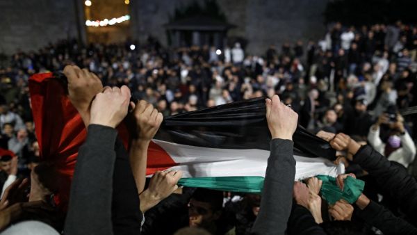 Palestinian protesters wave the national flag outside the Damascus Gate in Jerusalem's Old City on April 26, 2021. Ahmad GHARABLI / AFP Human Rights Watch is preparing a report that will accuse Israel of "apartheid."