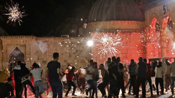 Stun grenades burst in the air amid clashes between Palestinian protesters and Israeli security forces at the al-Aqsa mosque compound in Jerusalem