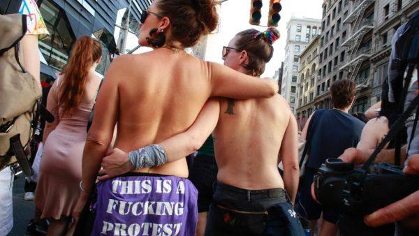 Topless attendees hold each other during the annual Dyke March