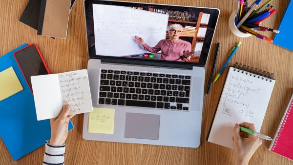 High angle view of video conference with teacher on laptop at home