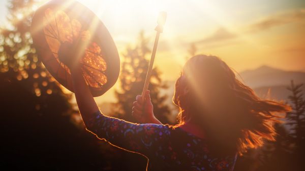 girl playing on shaman frame drum 