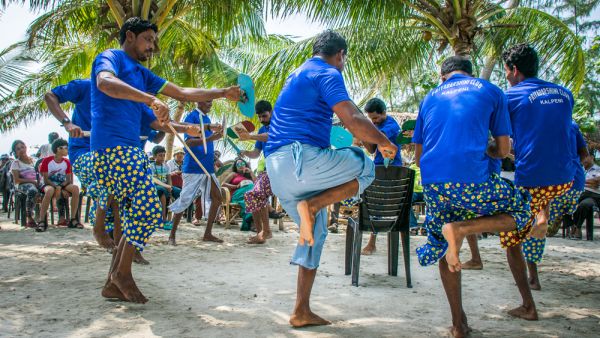  Kalpeni, Lakshadweep, Men performing traditional local dance on tropical island beach