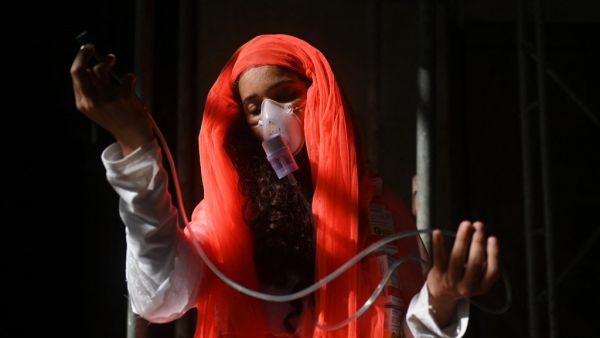 A woman wearing an oxygen face mask performs an act during a protest against the Brazilian President Jair Bolsonaro's handling of the COVID-19 pandemic in Rio de Janeiro, Brazil, on July 3, 2021. Thousands of Brazilians took to the streets Saturday to protest against President Jair Bolsonaro, who faces an investigation over an allegedly corrupt Covid vaccine deal. Andre Borges / AFP COVID-19 pandemic started from Wuhan in 2019
