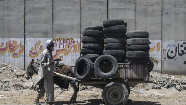 A man uses a rope to tie tyres on a donkey cart along a roadside in Kabul on July 27, 2021. SAJJAD HUSSAIN / AFP The US wants to help the government forces in Afghanistan