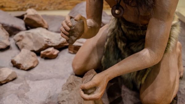 man set on fire with fire stone for cooking in stone age