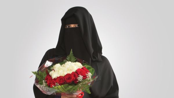 An Arab Saudi Woman holding flower bouquet standing in Saudi Arabia middle east gulf