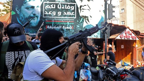 A Hezbollah fighter fires his gun 