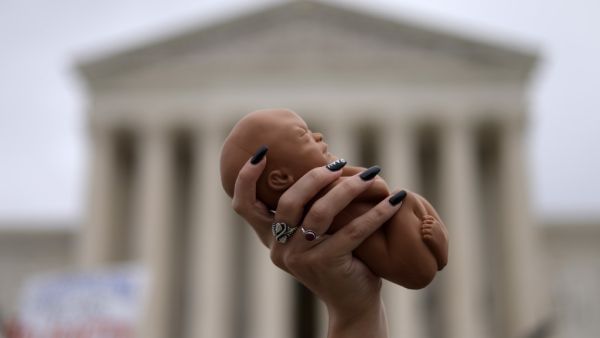 A pro-life activist holds up a baby doll during a rally for a ban on abortion in front of the U.S. Supreme Court October 12, 2021 in Washington, DC. Alex Wong/Getty Images/AFP  Oklahoma Supreme Court blocks 3 anti-abortion laws
