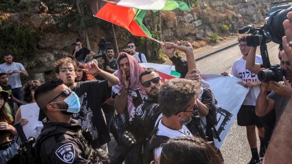 Israeli police confiscate a Palestinian flag from a protester during a demonstration by Palestinian, Israeli, and foreign activists against Israeli occupation and settlement activity in the Palestinian Territories and east Jerusalem, in Jerusalem's Palestinian Sheikh Jarrah neighbourhood on July 30, 2021. (Photo by AHMAD GHARABLI / AFP) Palestinian families facing eviction from their homes in Jerusalem’s Sheikh Jarrah