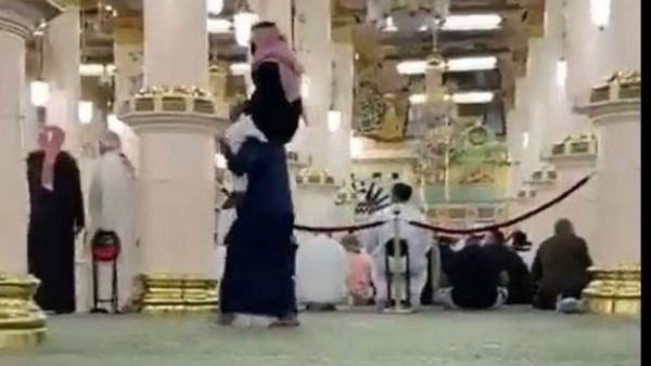 شاب يحمل والده على كتفيه بالمسجد النبوي