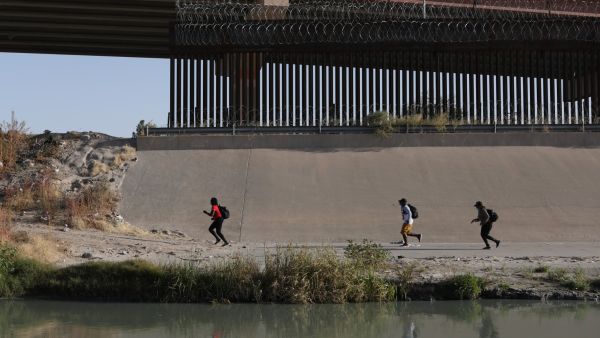 Haitian migrants run after crossing the Rio Bravo to seek political asylum in the US, as seen from Ciudad Juarez, Chihuahua state, Mexico, on December 6, 2021.(Photo by HERIKA MARTINEZ / AFP) Haitian migrants to file a lawsuit against US over treatment on border
