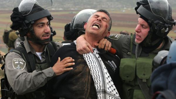 Israeli soldiers arrest a Palestinian 