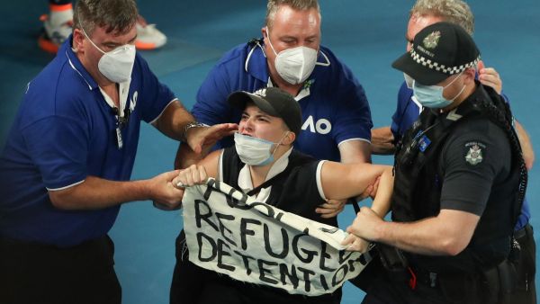 الفتاة تحمل لافتة كتب عليها "أوقفوا احتجاز اللاجئين"