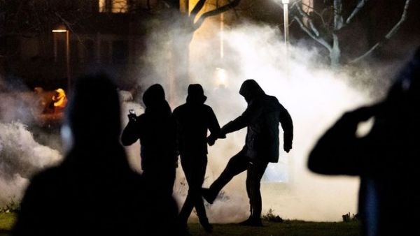 A protester kicks a tear gas canister at Rosengard in Malmo