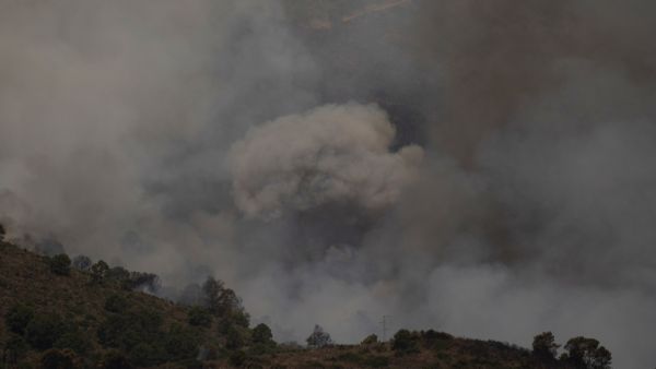 Smoke from a wildfire in Sierra Bermeja mountain range in Malaga is pictured from Benahavis on June 9, 2022. (Photo by JORGE GUERRERO / AFP) wildfire