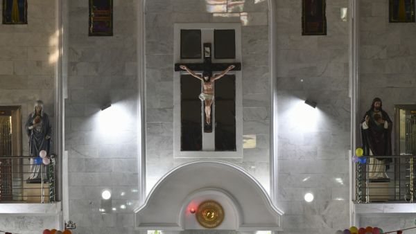 A crucifix is seen on the wall during a Christmas mass at St. Patrick's Church in Maiduguri on December 25, 2021. (Photo by Audu MARTE / AFP) church attack