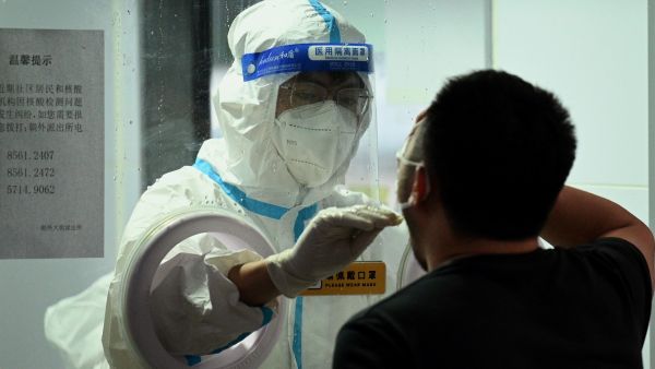 A health worker takes a swab sample from a man to test for the Covid-19 coronavirus in Beijing on June 21, 2022. (Photo by Noel Celis / AFP)