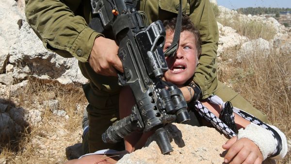Israeli soldier grabs a Palestinian kid 