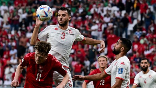 Denmark's midfielder #11 Andreas Skov Olsen (L) and Tunisia's defender #03 Montassar Talbi fight for the ball during the Qatar 2022 World Cup Group D football match between Denmark and Tunisia at the Education City Stadium in Al-Rayyan, west of Doha on November 22, 2022. (Photo by Miguel MEDINA / AFP)
