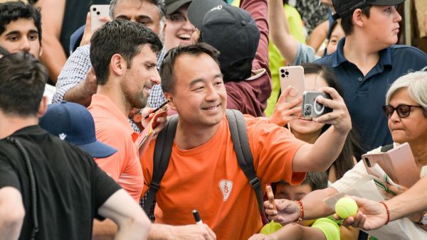Serbian tennis player Novak Djokovic has a selfie with a fan after his first round doubles match with Canadian Vasek Pospisil at the ATP Adelaide International tournament in Adelaide on January 2, 2023. (Photo by Brenton EDWARDS / AFP)